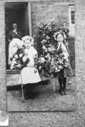 Daphne Bartlett (on left) taking loops of flowers around the village on 12th May
